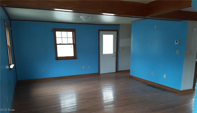 spare room featuring wood finished floors and baseboards