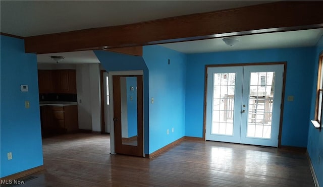 spare room featuring wood finished floors, french doors, baseboards, and beam ceiling