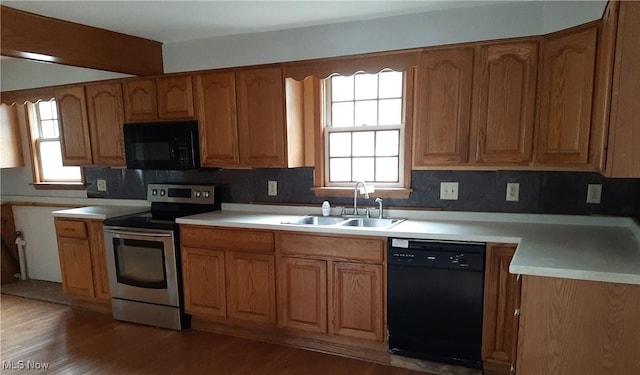 kitchen featuring black appliances, a healthy amount of sunlight, light countertops, and a sink