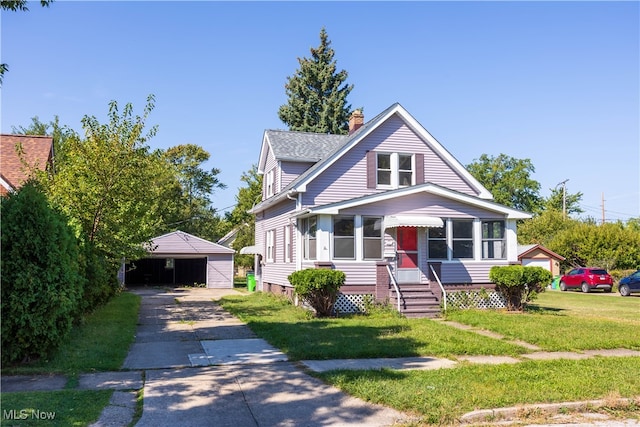 bungalow-style home featuring a front yard and an outbuilding