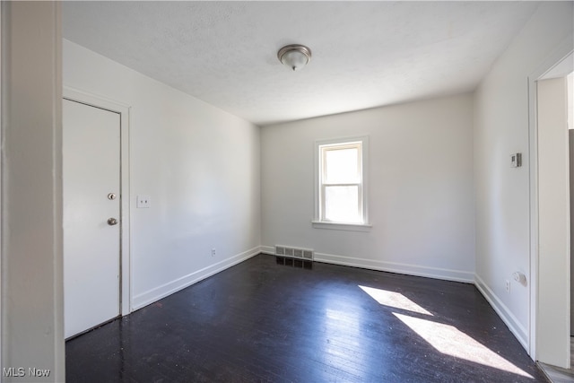 unfurnished room featuring dark hardwood / wood-style flooring