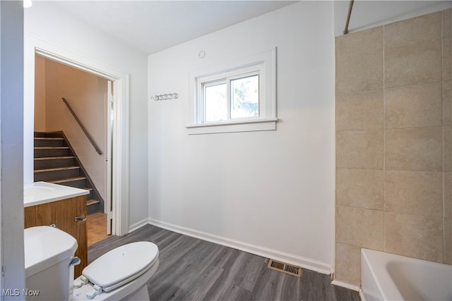 bathroom featuring wood-type flooring, vanity, and toilet