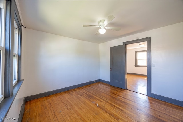 empty room with hardwood / wood-style floors and ceiling fan