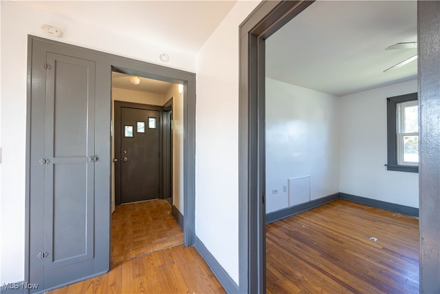 hallway with hardwood / wood-style floors