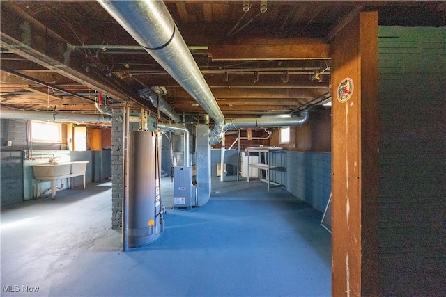 basement featuring heating unit, sink, and water heater