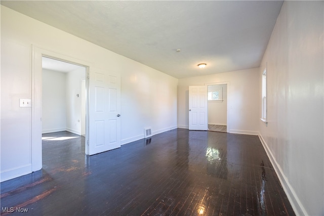 unfurnished room with dark wood-type flooring