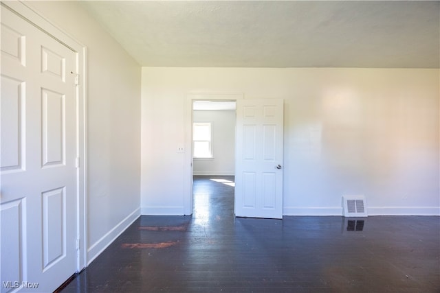 unfurnished room with dark hardwood / wood-style floors