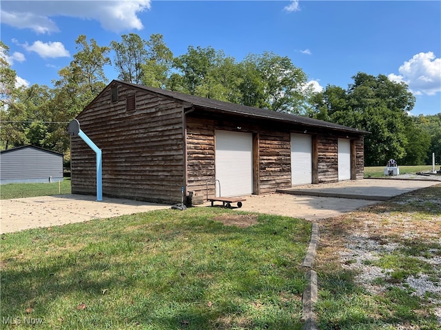 view of front of home with an outbuilding, a garage, and a front yard