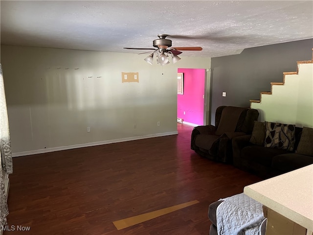 living room with ceiling fan, dark wood-type flooring, and a textured ceiling