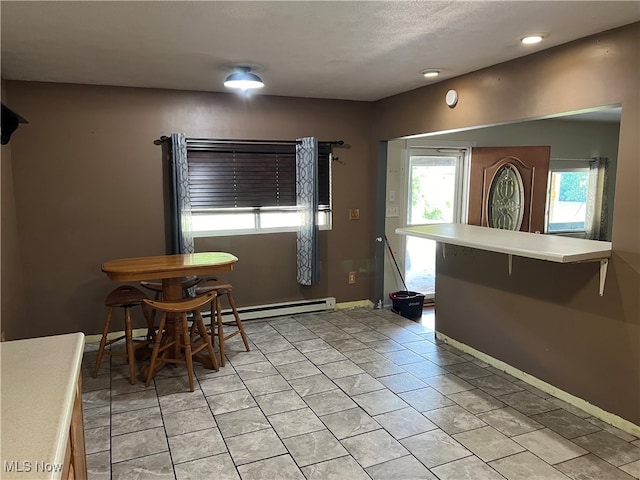 dining area featuring baseboard heating and a wealth of natural light