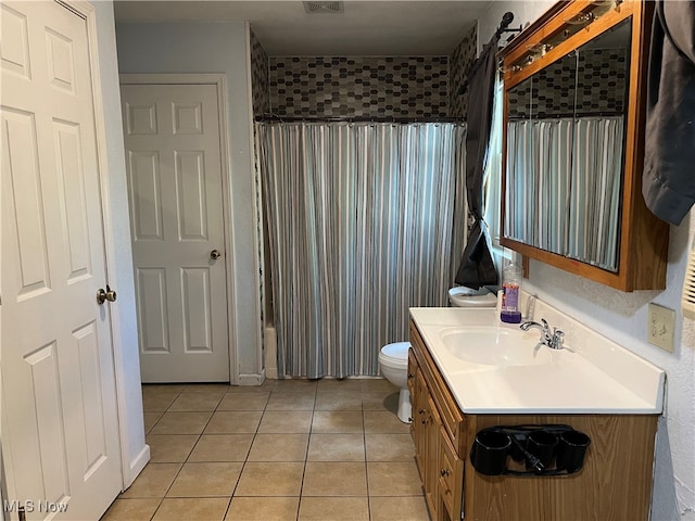 bathroom featuring tile patterned flooring, vanity, and toilet