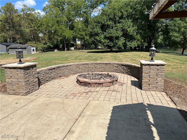 view of patio with a storage unit and a fire pit