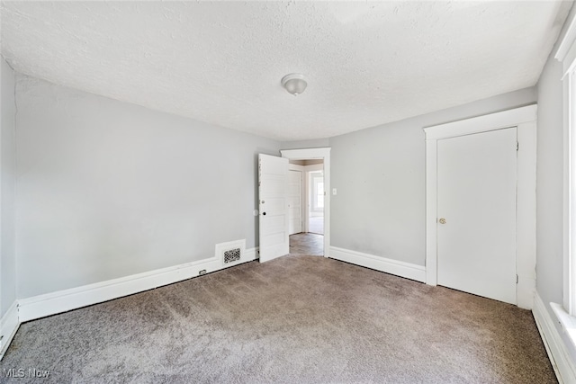 unfurnished bedroom featuring a textured ceiling and carpet