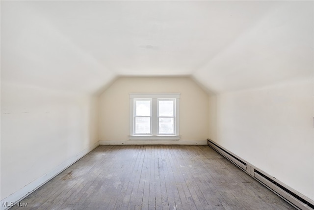 bonus room featuring light hardwood / wood-style floors, vaulted ceiling, and a baseboard radiator