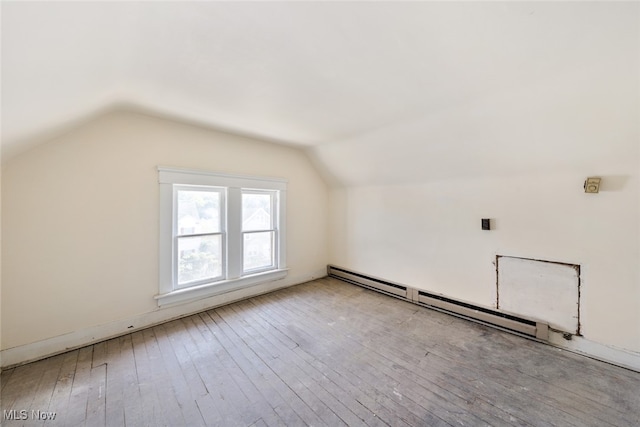 additional living space featuring light hardwood / wood-style floors, vaulted ceiling, and baseboard heating