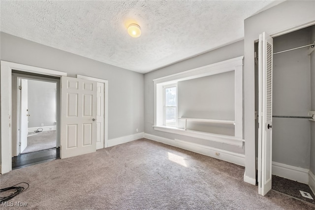 unfurnished bedroom featuring a closet, a textured ceiling, and carpet flooring