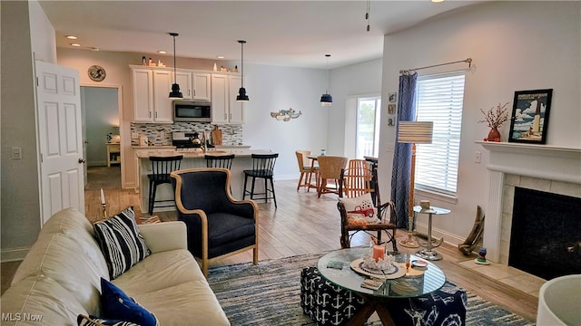 living room featuring light hardwood / wood-style floors and a tile fireplace