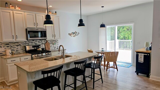 kitchen featuring white cabinets, light hardwood / wood-style floors, stainless steel appliances, and sink