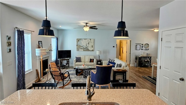 interior space with wood-type flooring, decorative light fixtures, ceiling fan, and a healthy amount of sunlight