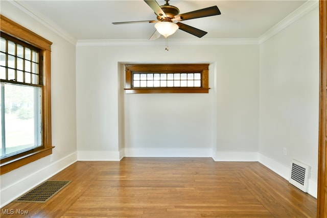 spare room featuring ornamental molding, light hardwood / wood-style floors, ceiling fan, and a healthy amount of sunlight