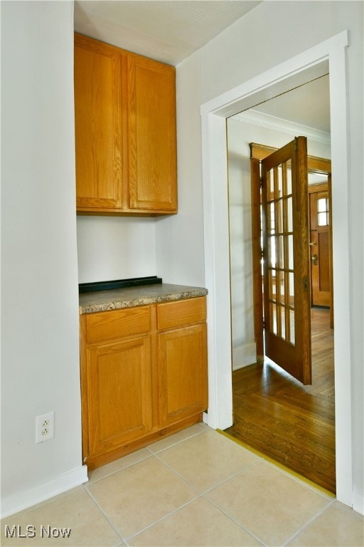 kitchen featuring light hardwood / wood-style floors and crown molding