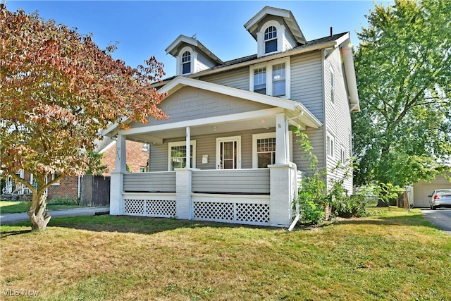 view of front of property with a front lawn, covered porch, and a garage