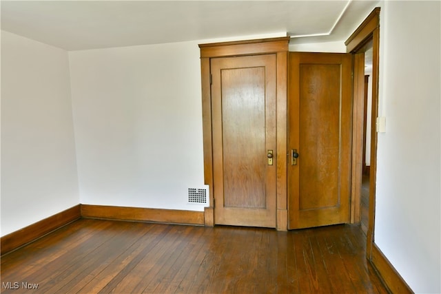 unfurnished bedroom with dark hardwood / wood-style flooring