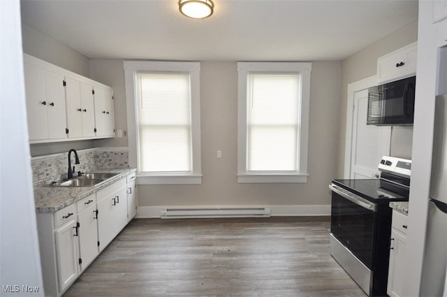 kitchen featuring stainless steel electric range, white cabinets, a baseboard radiator, wood-type flooring, and sink