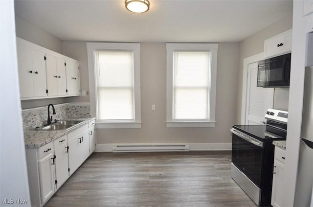 kitchen featuring black microwave, baseboard heating, electric range, white cabinetry, and a sink