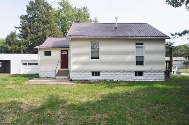 back of house with a yard and a garage