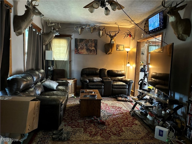 living room featuring a textured ceiling and ceiling fan