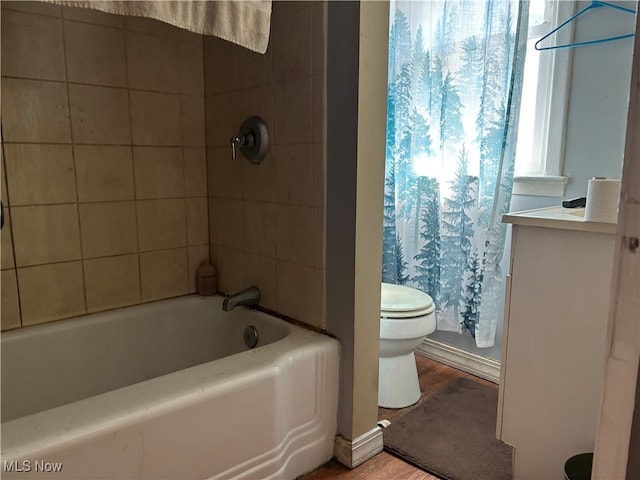 full bathroom with wood-type flooring, vanity, shower / bath combo with shower curtain, and toilet