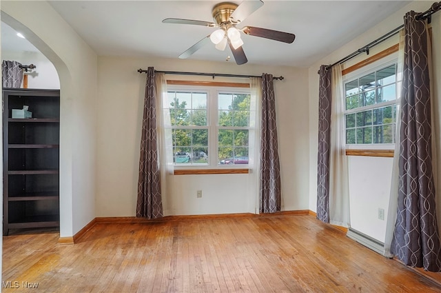 unfurnished room featuring light hardwood / wood-style floors, ceiling fan, and a healthy amount of sunlight