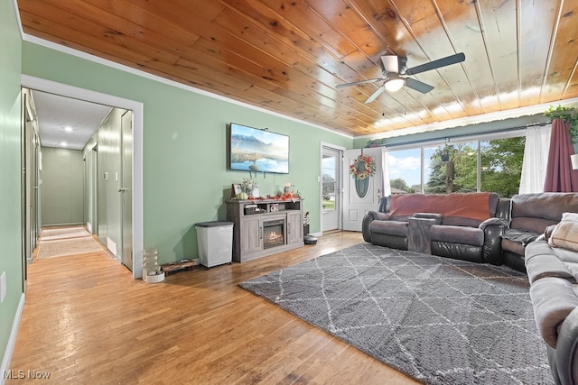 living room with wood ceiling, ornamental molding, ceiling fan, and hardwood / wood-style flooring