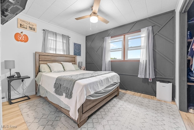 bedroom featuring ceiling fan, ornamental molding, and hardwood / wood-style floors