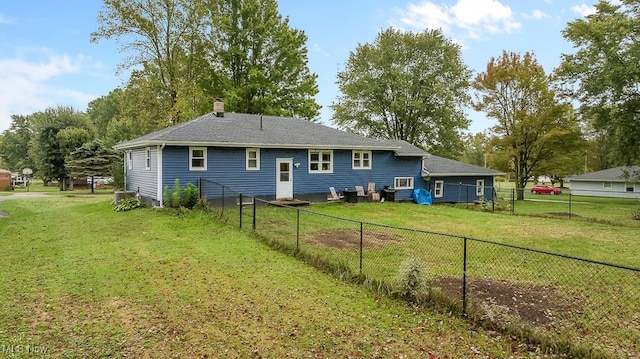 rear view of property featuring a lawn