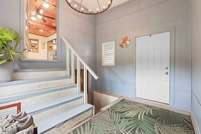 entrance foyer with ceiling fan with notable chandelier and wooden ceiling