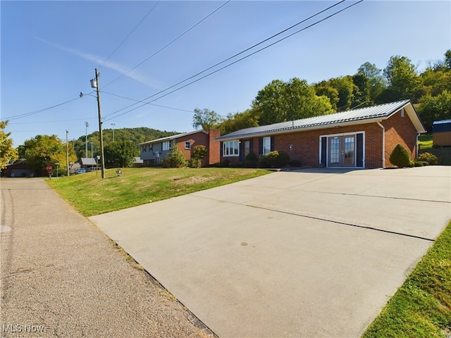 ranch-style home with a front lawn and french doors