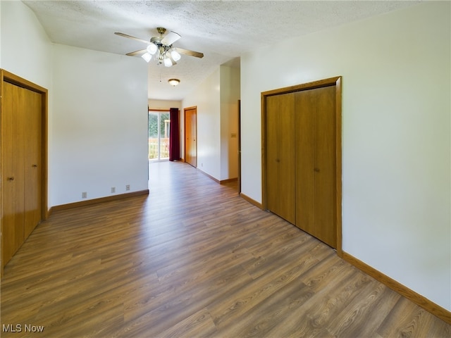 unfurnished room featuring a textured ceiling, dark hardwood / wood-style flooring, and ceiling fan