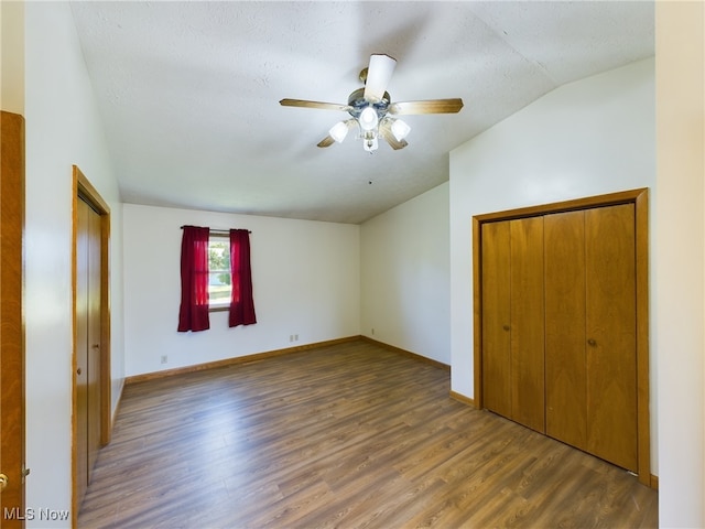 spare room featuring ceiling fan, a textured ceiling, dark hardwood / wood-style floors, and vaulted ceiling