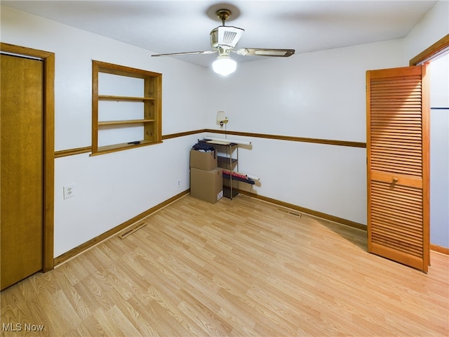 spare room with light wood-type flooring and ceiling fan