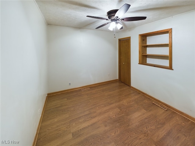 empty room featuring a textured ceiling, ceiling fan, and hardwood / wood-style flooring