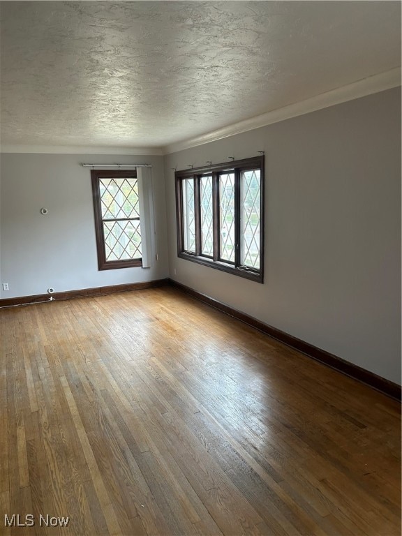 empty room featuring a textured ceiling and hardwood / wood-style flooring