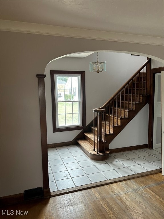 interior space featuring light hardwood / wood-style flooring, an inviting chandelier, and ornamental molding