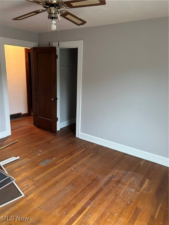 unfurnished bedroom with ceiling fan, a closet, and hardwood / wood-style flooring