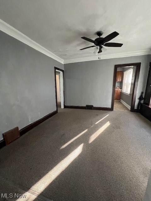 empty room with ornamental molding, ceiling fan, and light colored carpet