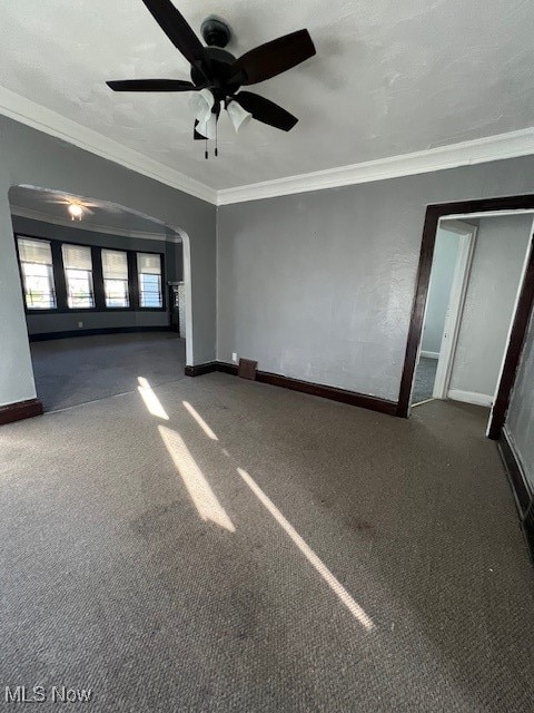 unfurnished bedroom with ceiling fan, dark colored carpet, and ornamental molding