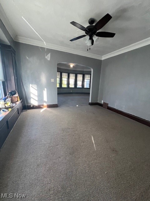 unfurnished living room featuring ornamental molding, carpet, and ceiling fan