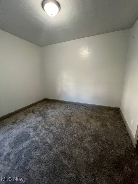 empty room featuring dark carpet