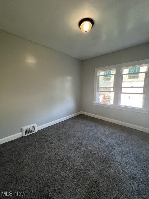 empty room featuring dark carpet